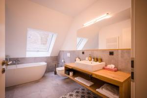 y baño con lavabo, bañera y aseo. en Brauereigasthof-Jakob en Nittenau