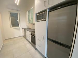 eine Küche mit einem Kühlschrank und einer Mikrowelle in der Unterkunft Panna Apartment Budapest in Budapest