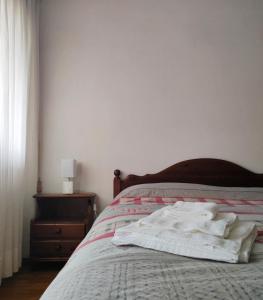 ピエーヴェ・ディ・カドーレにあるDolomiti Apartmentのベッド(白いタオル2枚付)