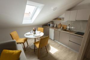 a kitchen and dining room with a table and chairs at Rooms & Apartment Perak in Kutjevo