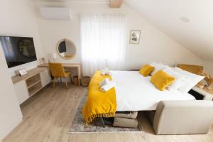 KutjevoにあるRooms & Apartment Perakのベッドルーム(大きな白いベッド1台、ソファ付)