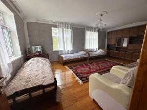 a living room with two beds and a couch at Vandam Luminous Villa in Gabala +12 photos