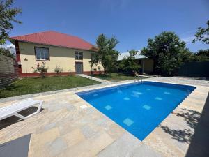 a swimming pool in front of a house at Vandam Luminous Villa in Gabala