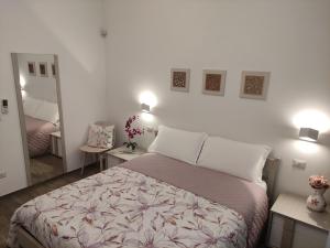 コンヴェルサーノにあるDimora Quattro Fontaneのベッドルーム1室(ベッド1台、ランプ2つ、鏡付)