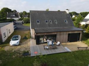 two people standing on a deck in front of a house at Ti Laouen Karaez in Carhaix-Plouguer