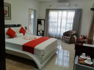 een slaapkamer met een groot bed en een woonkamer bij Girlie's bed and breakfast in Kopong