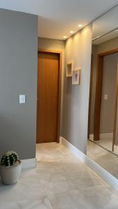 a hallway with a door and a potted plant at Temporada 203 in Vitória