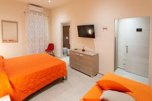 a hotel room with two beds and a television at The Bricks B&B Free Parking in Pisa