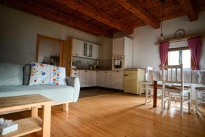 a living room with a blue couch and a kitchen at Švajkova chyža in Šumiac
