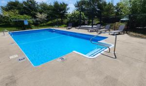uma grande piscina com duas cadeiras ao lado em Red Roof Inn & Suites Newport - Middletown, RI em Middletown