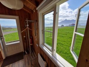 a bathroom with windows and a view of a green field at Berunes HI Hostel in Berunes