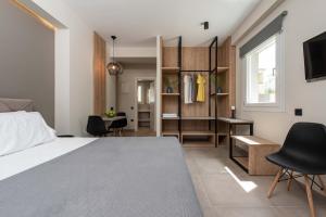 a bedroom with a bed and a desk and chairs at Val Del Mar in Skala Fourkas
