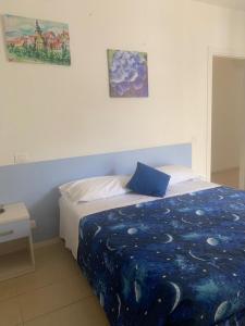 a bedroom with a bed with a blue comforter at Affittacamere LA CONTESSA in Siena