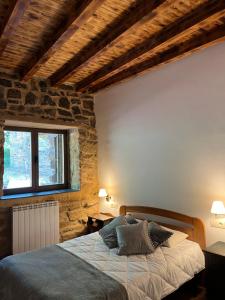 a bedroom with a bed in a stone wall at SANABRIA - Palacio de La Cuesta in Palacios de Sanabria
