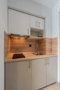 a kitchen with white cabinets and a sink at Val Del Mar in Skala Fourkas