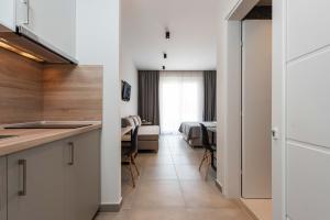 a kitchen with white cabinets and a room with a bed at Val Del Mar in Skala Fourkas