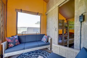 niebieską kanapę w pokoju z oknem w obiekcie Sunny Trio w mieście Zeewolde