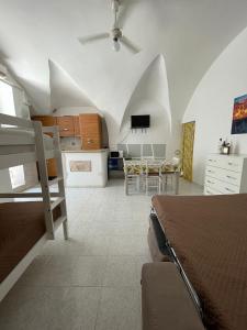 a room with a bed and a kitchen with a table at Dimora Marina sul Gargano in Vieste