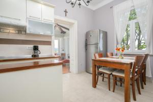 a kitchen with a table and chairs and a refrigerator at Apartment Gloria in Opatija