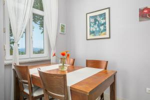 jadalnia ze stołem i krzesłami oraz oknem w obiekcie Apartment Gloria w mieście Opatija