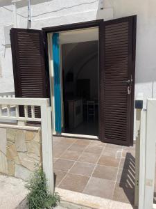 an open door to a patio with a white fence at Dimora Marina sul Gargano in Vieste