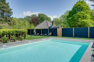 una piscina en un patio con una valla en Sunny Trio, en Zeewolde