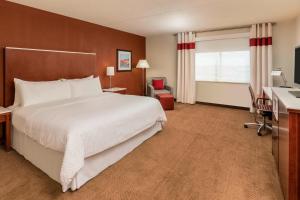 een hotelkamer met een groot bed en een bureau bij Four Points by Sheraton Boston Logan Airport Revere in Revere