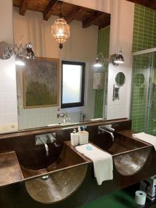 a bathroom with two sinks and a large mirror at SANABRIA - Palacio de La Cuesta in Palacios de Sanabria +22 photos