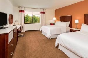 a hotel room with two beds and a flat screen tv at Four Points by Sheraton Boston Logan Airport Revere in Revere