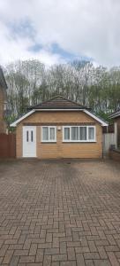 une maison avec des portes blanches et une allée en briques dans l'établissement Beautifully designed private studio in Telford near M54 J4, à Telford