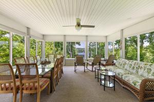 a screened in porch with a couch and tables and chairs at Heron Hideaway in Wilkesboro +24 photos