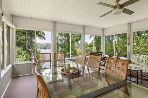 a screened in porch with a glass table and chairs at Heron Hideaway in Wilkesboro