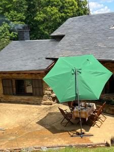 a green umbrella sitting in front of a house at SANABRIA - Palacio de La Cuesta in Palacios de Sanabria
