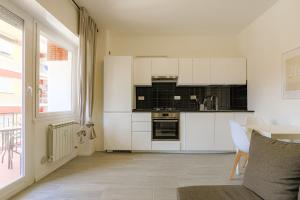 cocina con armarios blancos, mesa y ventana en Tiburtina FLAM guest house, en Roma