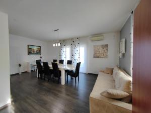 sala de estar con sofá, mesa y sillas en 3 bedrooms Apartman DMT, en Kaštela