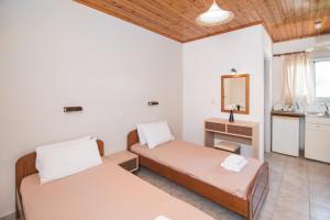 a room with two beds and a sink at Sandy Beach Annexe in Kavos