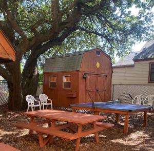 a ping pong table and picnic tables in front of a shed at Angie's Guest Cottage in Virginia Beach