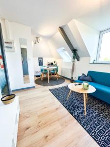 sala de estar con sofá azul y mesa en NEW: Le Lumineux face à la gare !, en Guingamp
