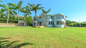 a large house with palm trees in front of it at Stylish Loft Style Apartment in Durban