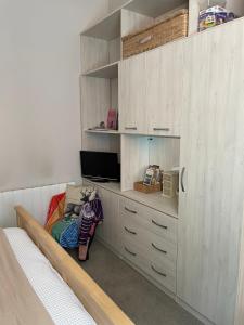 een kamer met een bed en een kast met een televisie bij Morning Sun Apartment Glastonbury in Glastonbury