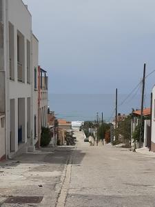 eine leere Straße in einer Stadt mit dem Ozean im Hintergrund in der Unterkunft Casa vacanze LE TERRAZZE Triscina di Selinunte in Triscina