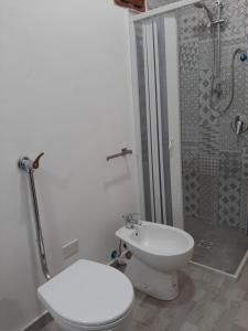 ein weißes Bad mit einem WC und einer Dusche in der Unterkunft Casa vacanze LE TERRAZZE Triscina di Selinunte in Triscina