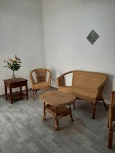 Zimmer mit Korbstühlen, einem Tisch und einer Blumenvase in der Unterkunft Casa vacanze LE TERRAZZE Triscina di Selinunte in Triscina