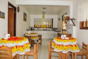 a dining room with two tables and chairs and a kitchen at Pousada Farol do Porto Nova ADM 2026 in Porto De Galinhas