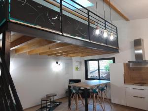 a kitchen with a table and chairs and a loft at La Remise de Francillon in Francillon-sur-Roubion