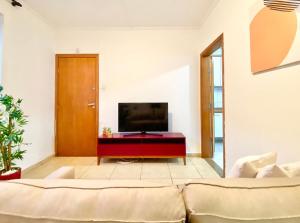 a living room with a couch and a flat screen tv at Canal 5 Embaré a 500 m da Praia in Santos
