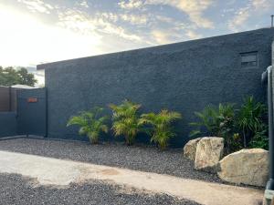 a building with a door and some plants and rocks at Miki Miki House in Fare