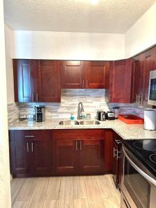 a kitchen with wooden cabinets and a sink at New Star Suite One in North Miami Beach