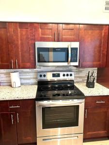a kitchen with a stove and a microwave at New Star Suite One in North Miami Beach