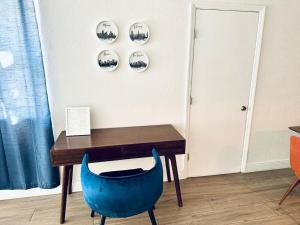 a blue chair sitting in front of a wooden desk at New Star Suite One in North Miami Beach